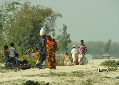 Two young men ready for migration (luggage in hand and on the head) in a village in Jatnapur in Northern Bangladesh. This village has been largely destroyed by riverbank erosion.